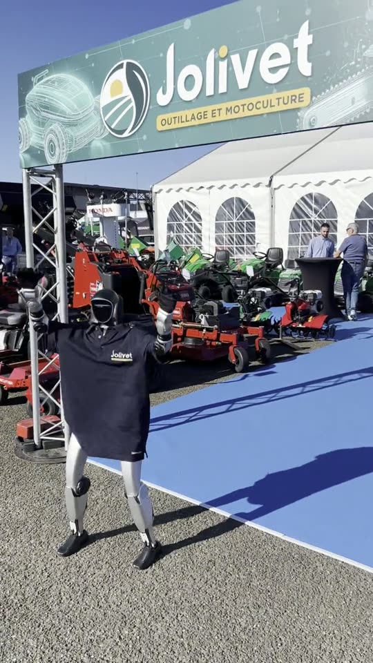 Le robot en polo Jolivet marche vers le stand sous l'enseigne Jolivet