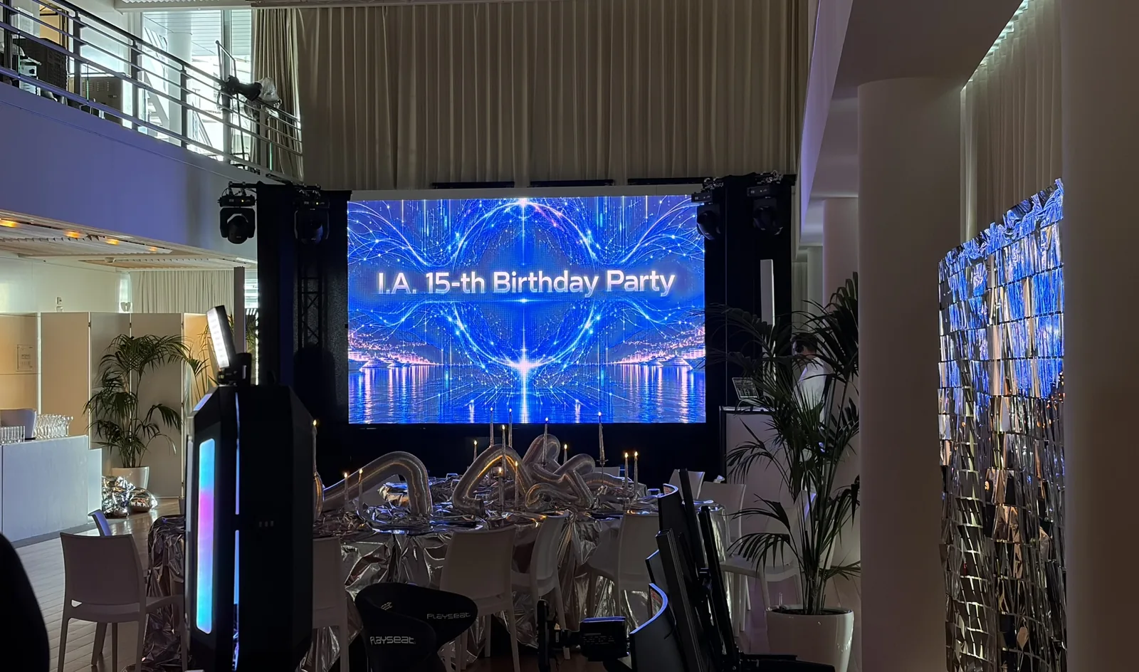 La salle Ballroom du Yacht Club de Monaco avant les invités : l'écran géant de la fête entre deux tours de projecteurs, les tables décorées, la mezzanine et la borne photo